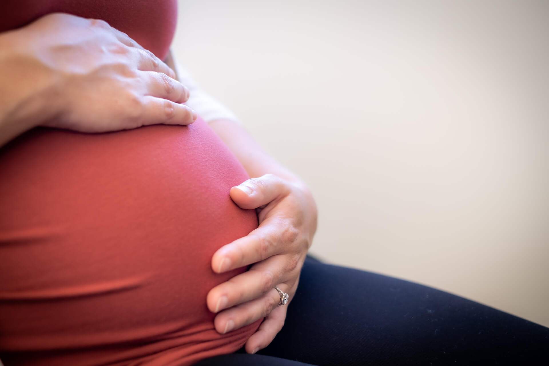 Pregnant woman cradles her baby bump