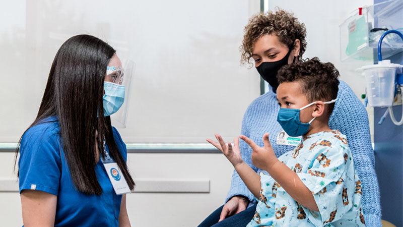 Provider speaks to child with parent in background