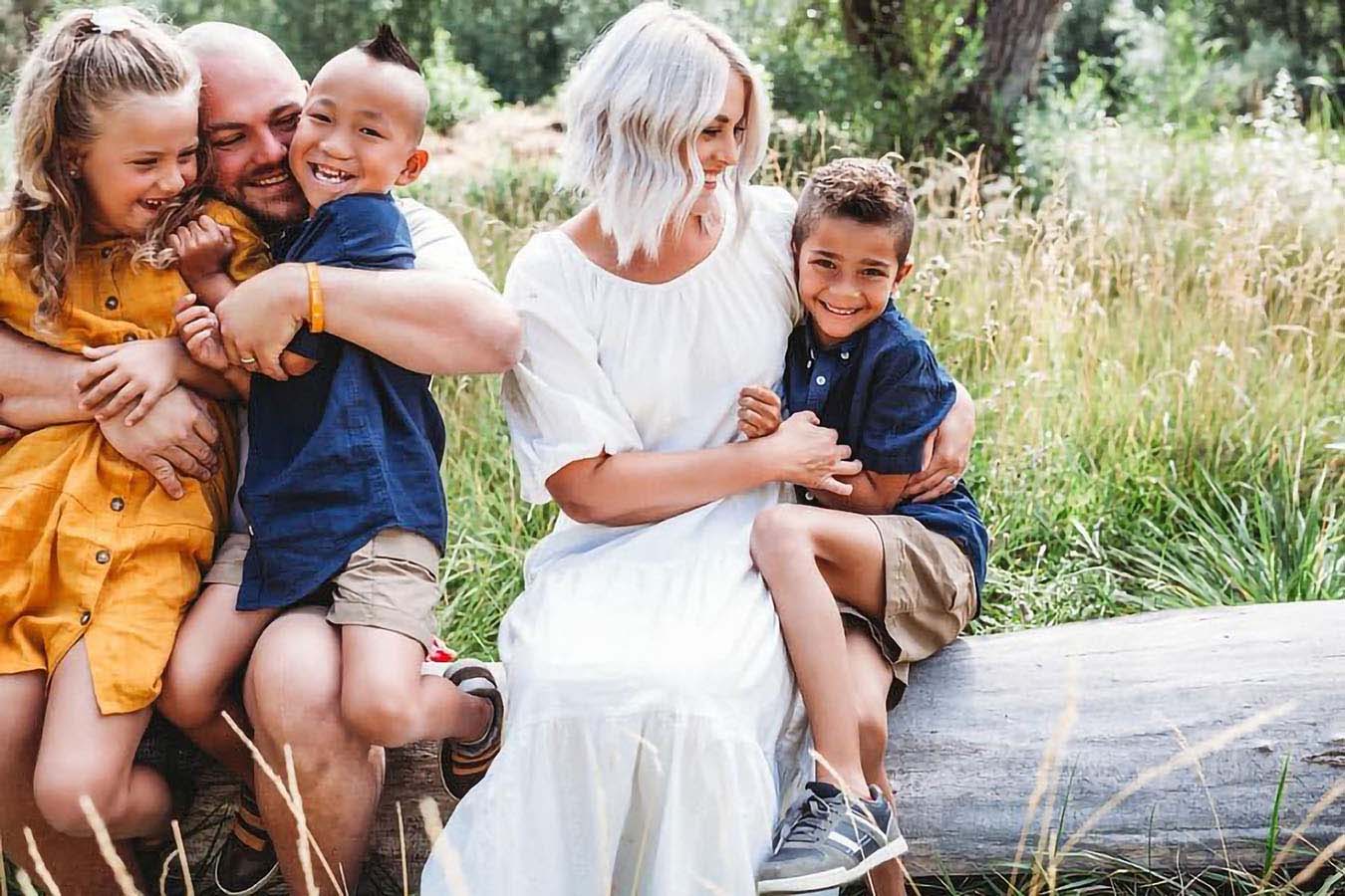 A family smiles outside