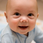 baby laying on stomach looking at camera